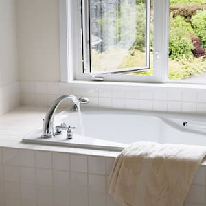 White tiled bathtub by an open window