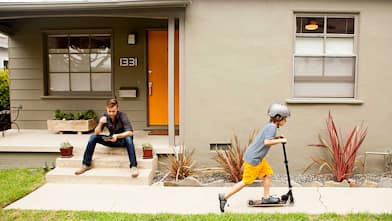 Kid playing with scooter in the front yard