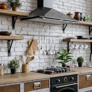 A kitchen interior with a range hood above the gas stove