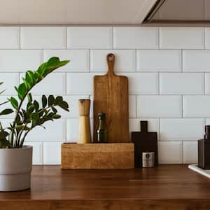 Kitchen with white tiles wall and wood table