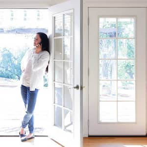 Woman using her phone standing in front of a french door