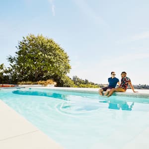 A couple discussing while sitting at the edge of their pool