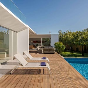 A beatufitul house with a swimming pool and a wooden deck