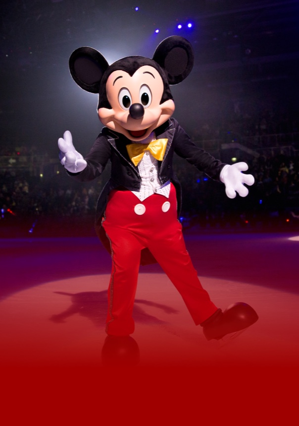 Mickey Mouse standing on stage with his hands out