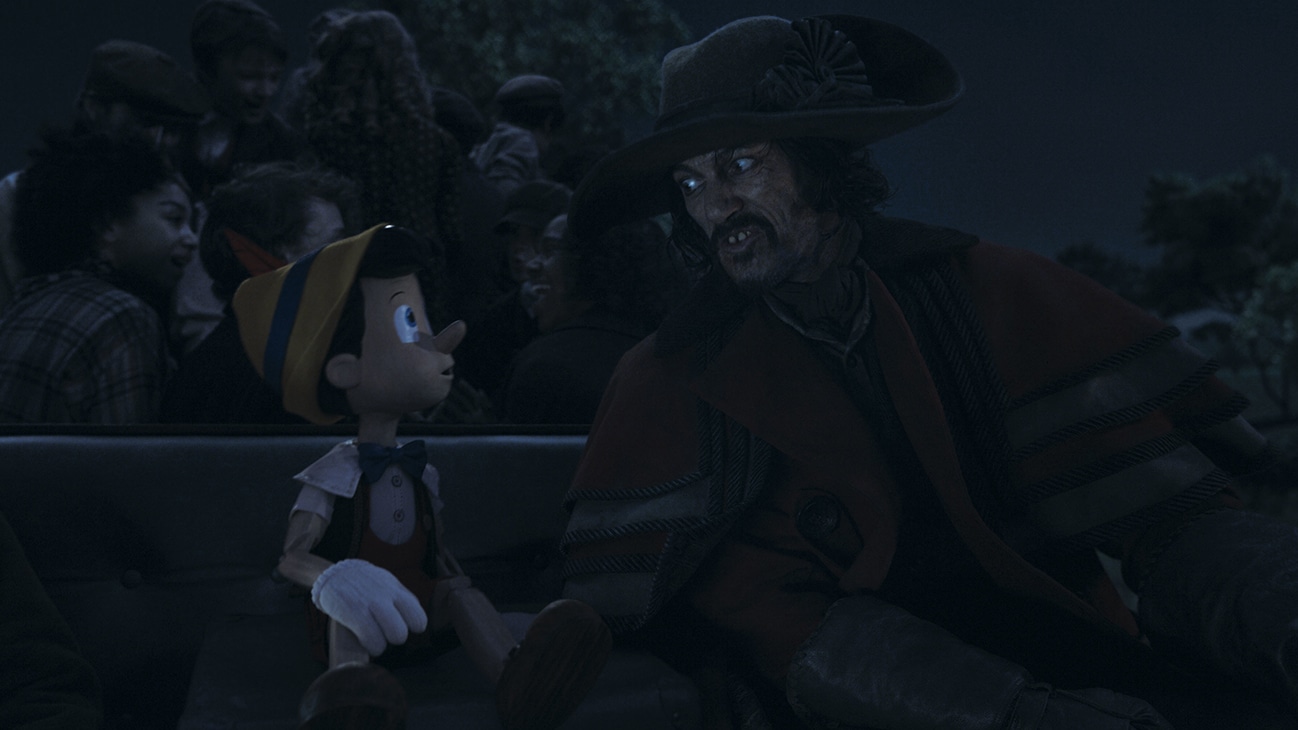 (L-R): Pinocchio (voiced by Benjamin Evan Ainsworth) and Luke Evans as The Coachman in Disney's live-action PINOCCHIO, exclusively on Disney+. Photo courtesy of Disney Enterprises, Inc. © 2022 Disney Enterprises, Inc. All Rights Reserved.