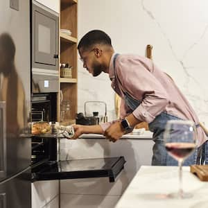 Man removing baked food from the oven