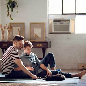 Couple sitting on the floor playing with their cat