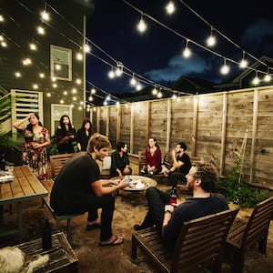 Friends at an outdoor party sitting in front of wooden fence