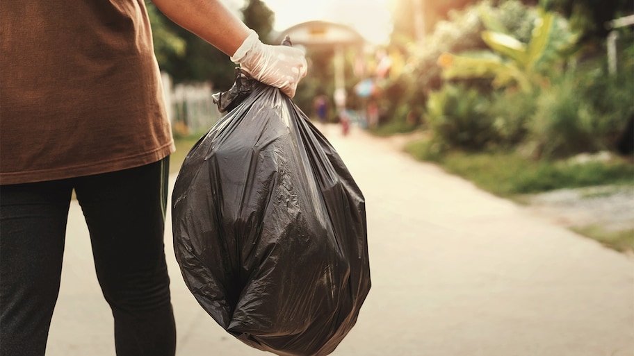 Man removing waste in trash back