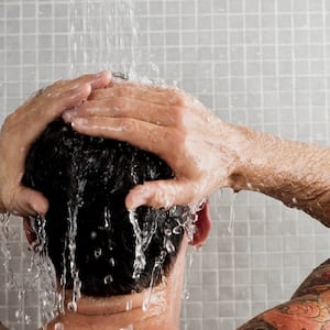 Man in shower with water running over him