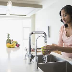 Woman washes grapes in kitchen sink