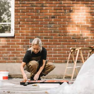 Woman crouching while renovating house 