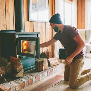 Man adding wood to the wood stove