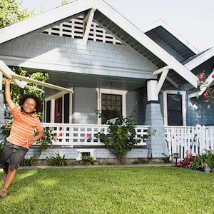 Boy playing with airplane in his front yard