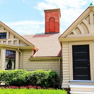 Cottage with brick chimney and wood siding