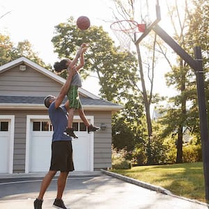 father plays basketball with son at home
