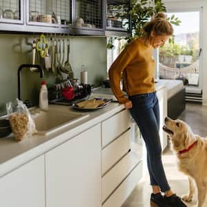 A woman and her dog in a kitchen at the morning