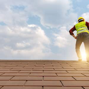 A worker stands on a roof