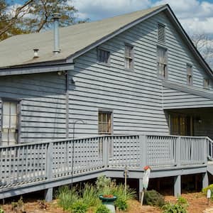 A gray wooden house with a wheelchair ramp