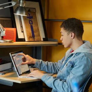 photo of young man using a computer on his desk at home