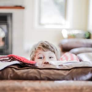 A young boy peeks above the cushions