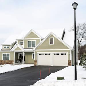 a home with snow on the grass and a clear driveway