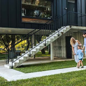 Family walking on a concrete walkway outside their home