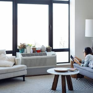 Young woman lying on the couch reading a book 