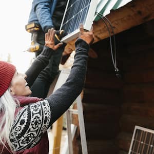 Happy woman installs solar panels