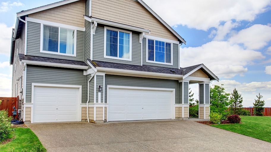 grey and beige house with concrete driveway