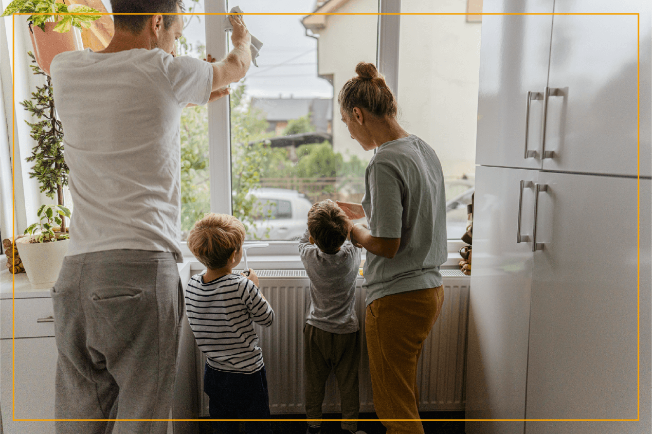 family with two kids cleaning windowsill