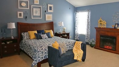 A bedroom decorated in French Country style with blue and yellow accents. 