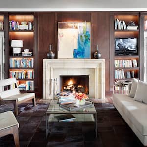 Library sitting room with built-in bookcases and a white fireplace