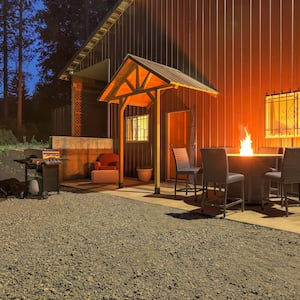  A large metal barndominium with a patio set and propane fireplace outside the front door