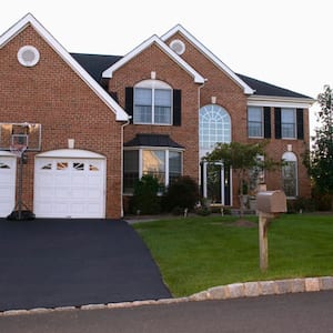 suburban home with red brick and asphalt driveway