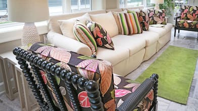 Attractive, uncluttered living room with couch and colorful chairs. 