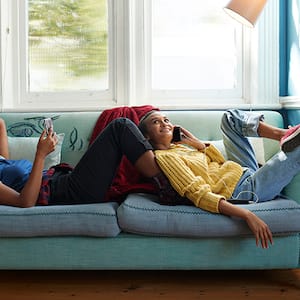 Two girls laugh in room with dark walls and light trim