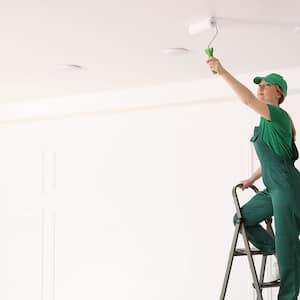 Woman on a ladder painting ceiling