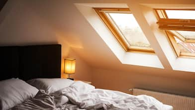  A cozy bedroom with a white bed and skylights