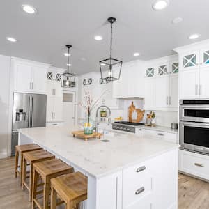 Modern farmhouse kitchen with white marble counters and cabinets