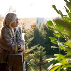 A woman standing by wooden house