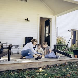 Mother and children playing checkers on outdoor porch