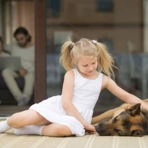 Girl petting dog on porch