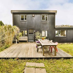 A two story house with a deck in the backyard