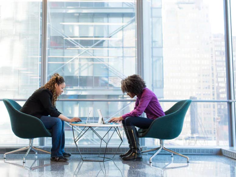 two people working together on computers