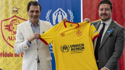 Giovanni Bassu, Representante de ACNUR en Ecuador, y Julián Pástor, Gerente General de Sociedad Deportiva Aucas, muestran la camiseta oficial del club de fútbol quiteño para el año 2023, tras la firma de un acuerdo que promoverá la inclusión de las personas refugiadas a través del deporte.