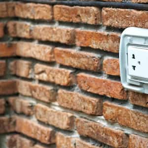 Outdoor white Electrical Outlet on brick wall