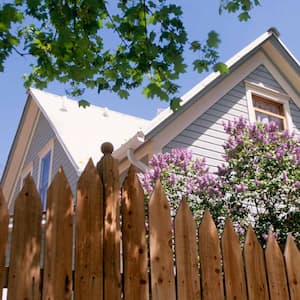 Wooden house behind fence