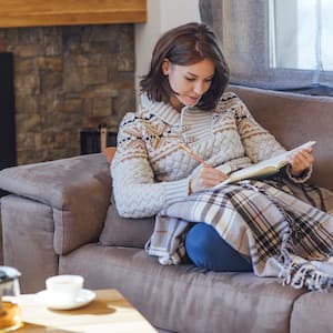 woman laying on couch under a blanket