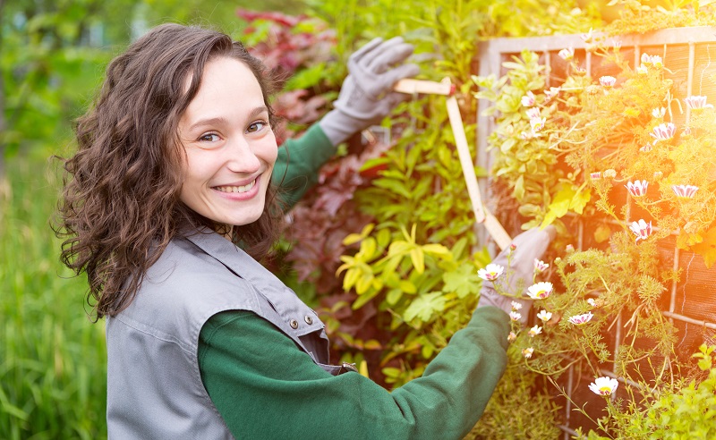 View of a Young attractive landscaper woman working in a yard